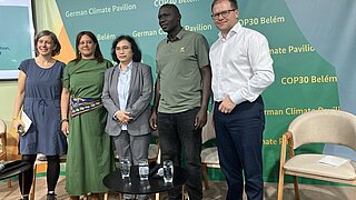 Fünf Personen stehen vor einer Wand mit dem Schriftzug 'COP30 Belém' und 'German Climate Pavilion'.