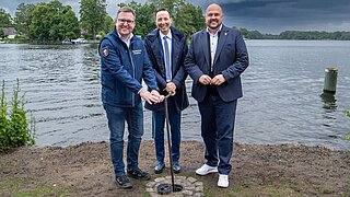 Frank Bewig (Bezirksbürgermeister), Thorsten Schatz (Bezirksstadtrat) und Oliver Conz (Abteilungsleiter für Naturschutz, Nachhaltige Naturnutzung und Natürlichen Klimaschutz im BMUKN) eröffnen die neue Anlage zur Wasserstandsregulierung