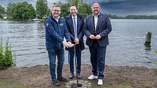 Frank Bewig (Bezirksbürgermeister), Thorsten Schatz (Bezirksstadtrat) und Oliver Conz (Abteilungsleiter für Naturschutz, Nachhaltige Naturnutzung und Natürlichen Klimaschutz im BMUKN) eröffnen die neue Anlage zur Wasserstandsregulierung